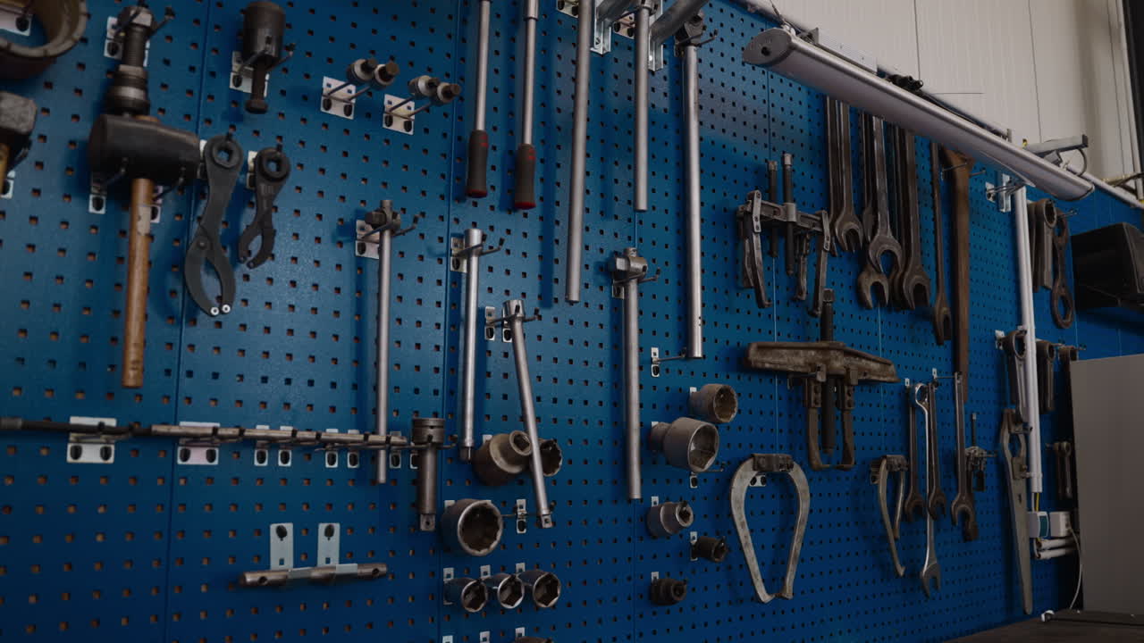 Organized tools hanging on a blue pegboard in a workshop. Perfect for DIY or industrial project visuals