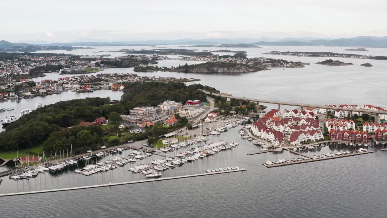 vista aérea de la costa de noruega de la ciudad de stavanger, isla de grasholmen, barcos en el puerto deportivo y el paso elevado de la carretera de bybrua, disparo de drones