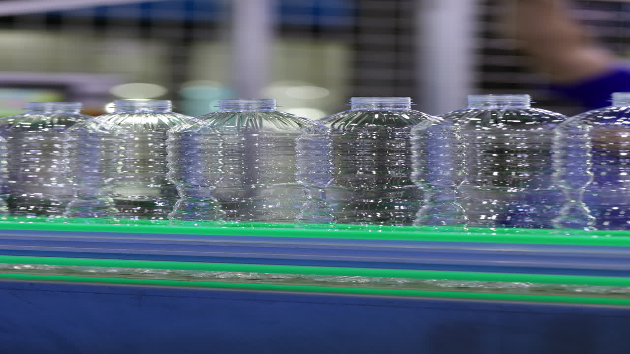 Empty Plastic Bottles Moving on Conveyor Belt in Factory