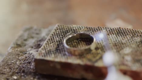 close up of shaping ring with blowtorch in workshop in slow motion