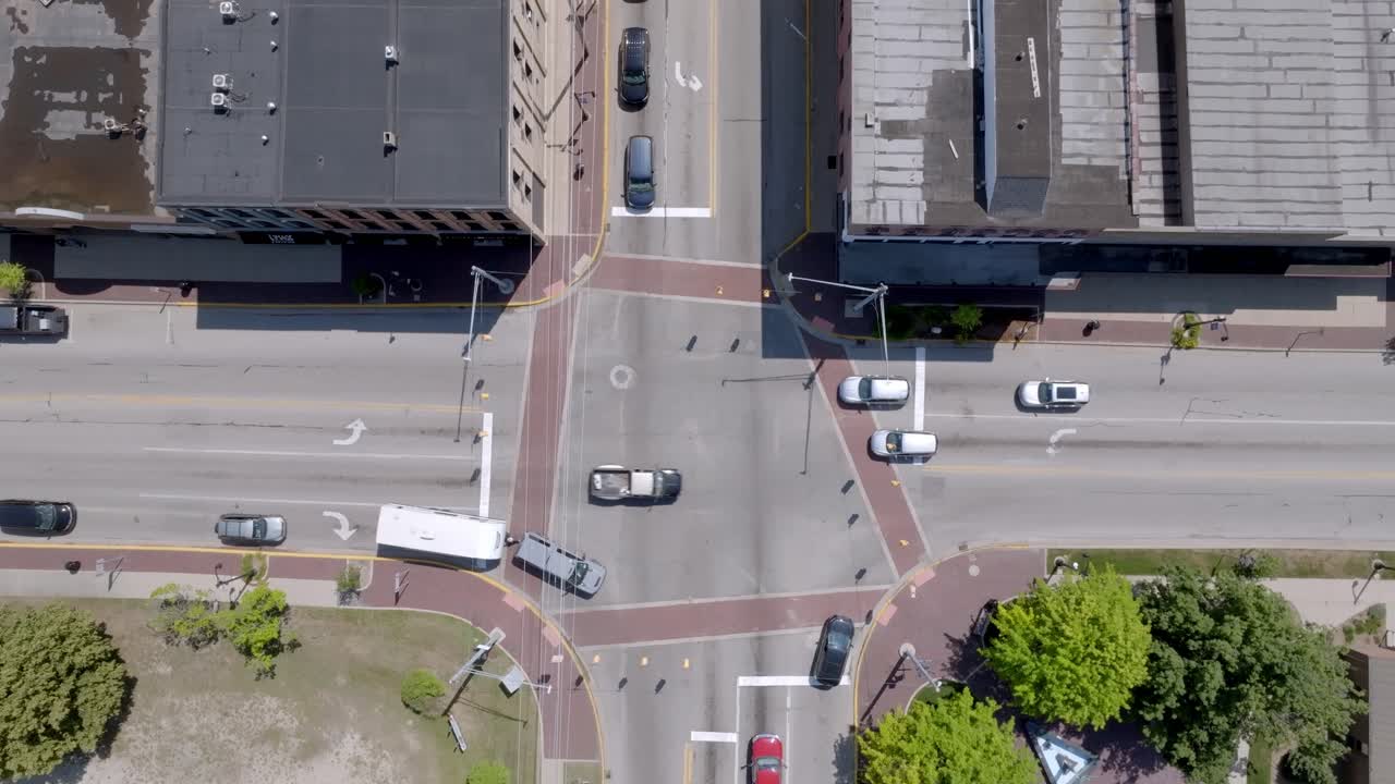 Intersection of traffic in downtown Greenville, Michigan with drone video overhead
