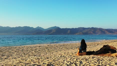 Junge-Frau-Erkundet-Exotischen-Sandstrand-Vor-Einem-Wunderschönen-Meereshintergrund-Mit-Vulkanischen-Bergen-Einer-Tropischen-Insel,-Indonesien