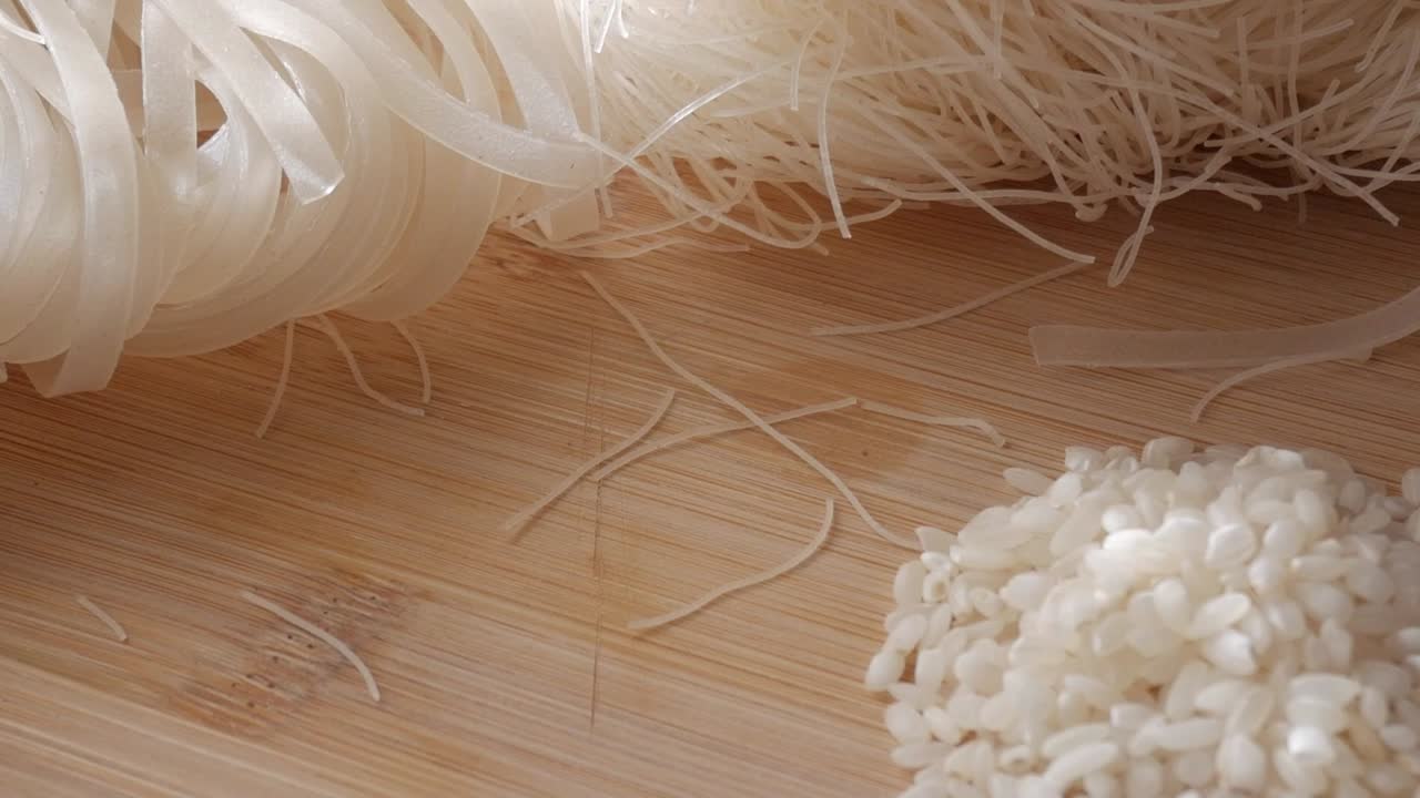 Thin rice noodles, close-up of vermicelli and flat noodles on a wooden surface