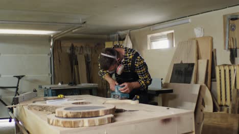 woodworker sanding wood pieces in a workshop