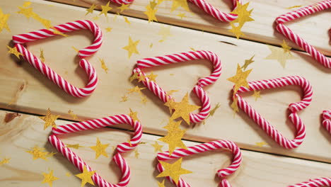 animation of stars over candy canes on wooden backrgound