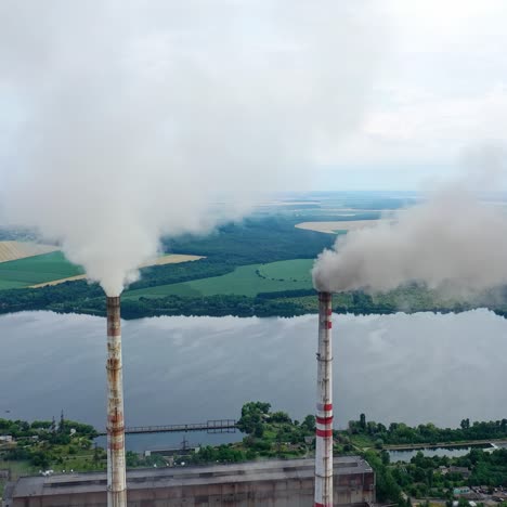 white stack of smoke coming out from large chimneys. factory chimneys releases harmful emissions into the atmosphere on nature backdrop.environmental problems