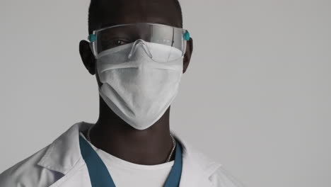 happy african american doctor on grey background.