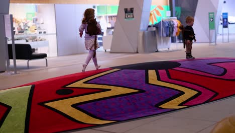 kids running on colorful carpet indoors