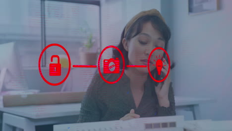 animación de una red de iconos digitales contra una mujer asiática feliz hablando en un teléfono inteligente en la oficina