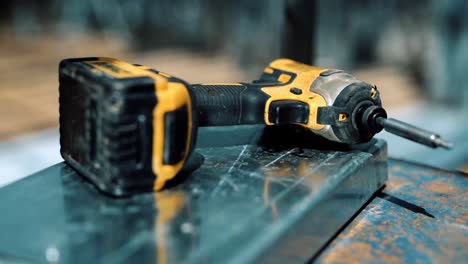 handheld cordless drill on stainless steel square bar