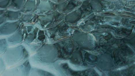 macro shot showing patterns of icelandic iceberg in blue and green colors - panning shot