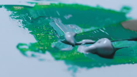 blue green and gray paint are mixed together to make an aqua green color