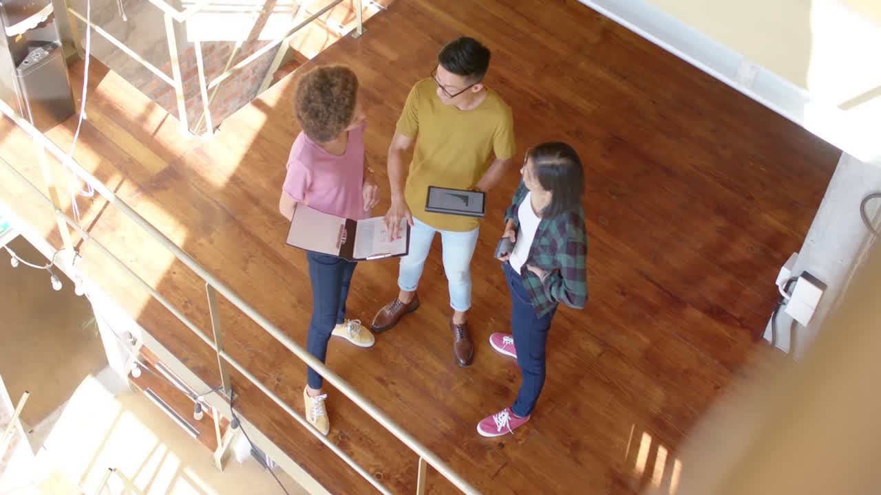 alto ángulo de diversos colegas masculinos y femeninos en una discusión casual en el pasillo, cámara lenta