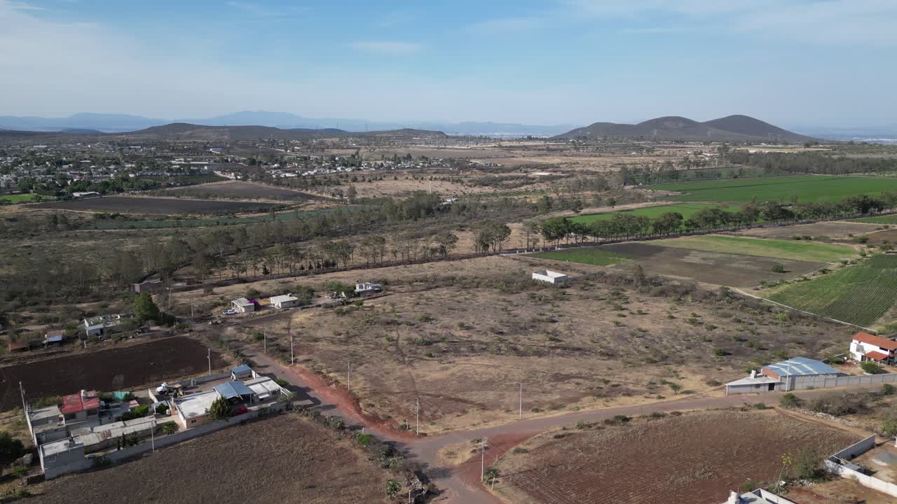 Crop field, aerial drone shot of an urban area.