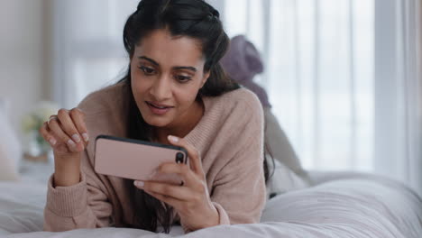 beautiful-woman-using-smartphone-browsing-online-watching-entertainment-enjoying-mobile-phone-checking-social-media-messages-lying-on-bed-at-home