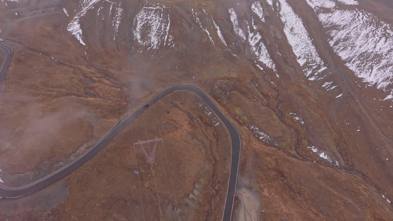 Drone captures Stelvio Pass in fall fog, winding roads, Italy