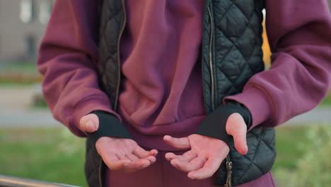 hand view of athlete rubbing her palms together outdoors, preparing for workout, focused athlete in activewear, emphasizing fitness routine and warm up techniques before exercise