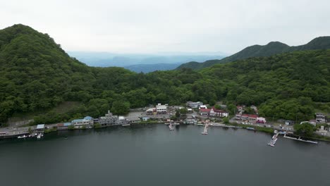 Calm drone scenery over small fishing town at lake shore in Japan