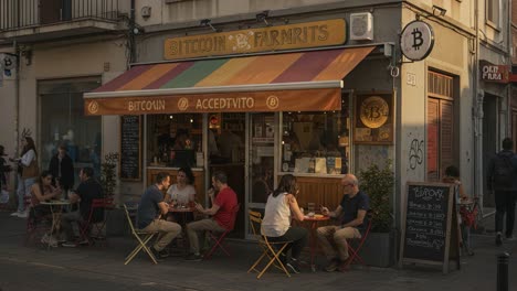 a vibrant café scene featuring diners enjoying refreshments outside a bitcoin-themed establishment during golden hour