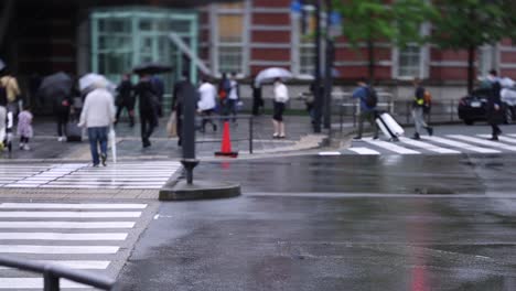 walking people on the street in marunouchi tokyo rainy day