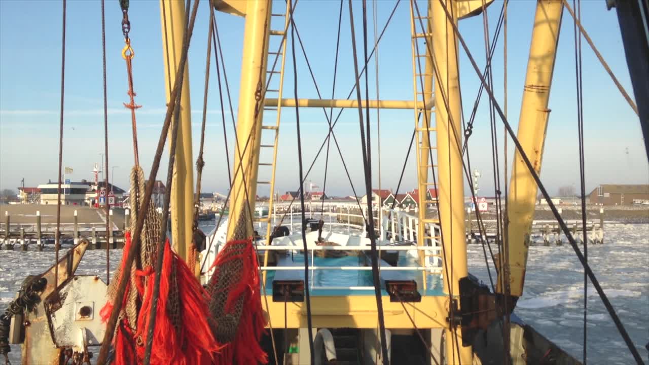 화창한 겨울날 얼어붙은 항구로 항해하는 어선 다리에서 pov