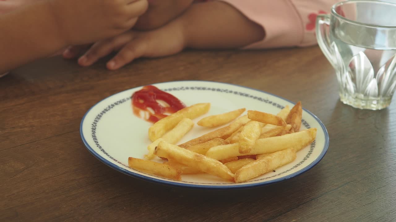 Child eating french fries and drinking water
