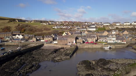 Aerial-footage-of-Gourdon-village-and-fishing-harbour-on-a-sunny-day,-Aberdeenshire,-Scotland