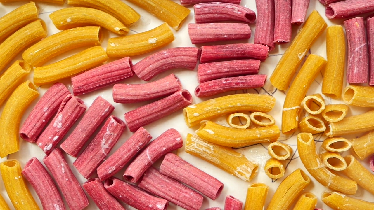 Vibrant Yellow and Pink Uncooked Pasta Shapes Drying