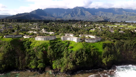 Toma-Aérea-De-Condominios-De-Lujo-En-Princeville,-Hola-Con-Montañas-Esmeralda-Sobre-Acantilados