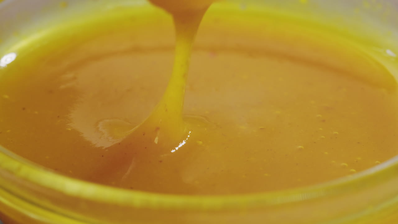 Fries being dipped in a yellow sauce