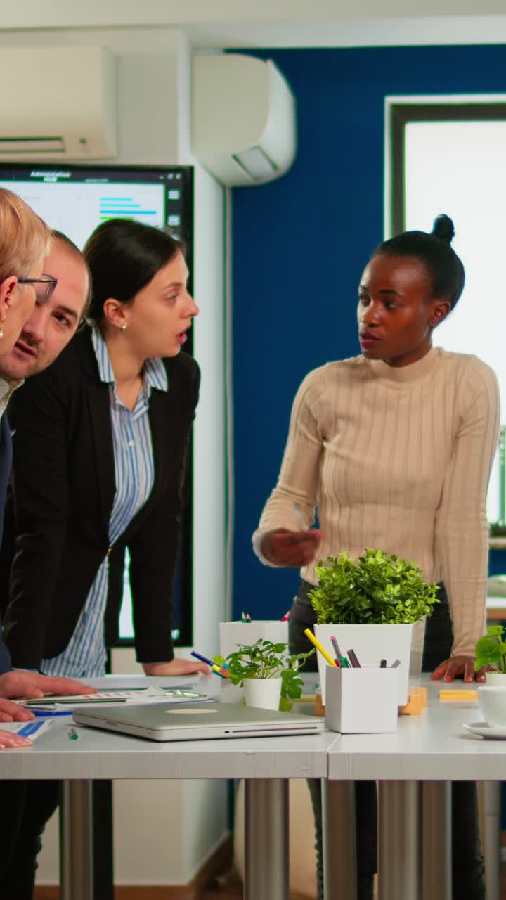 Vertical video Diverse businesspeople brainstorming while meeting at company office