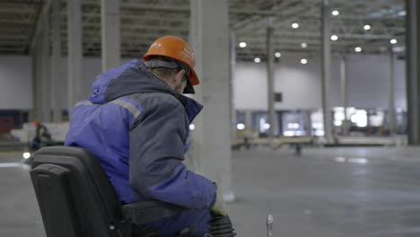 worker operating industrial vehicle in large warehouse