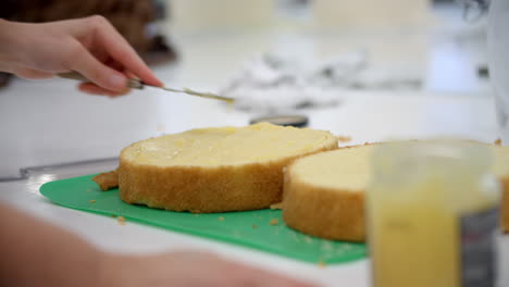 Mujer-En-Panadería-Extendiendo-Relleno-Para-Pastel-Con-Un-Cuchillo