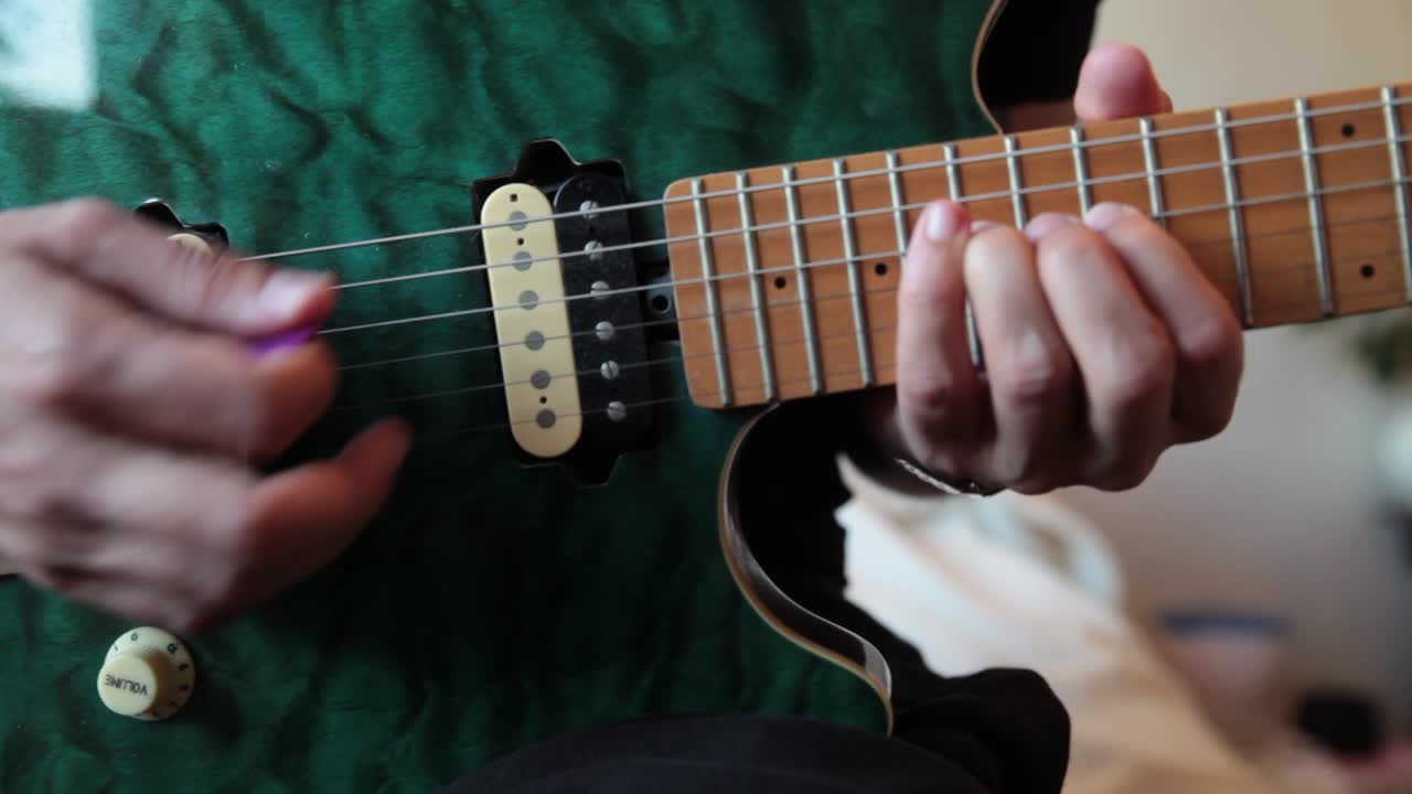Young man playing a blue electric guitar