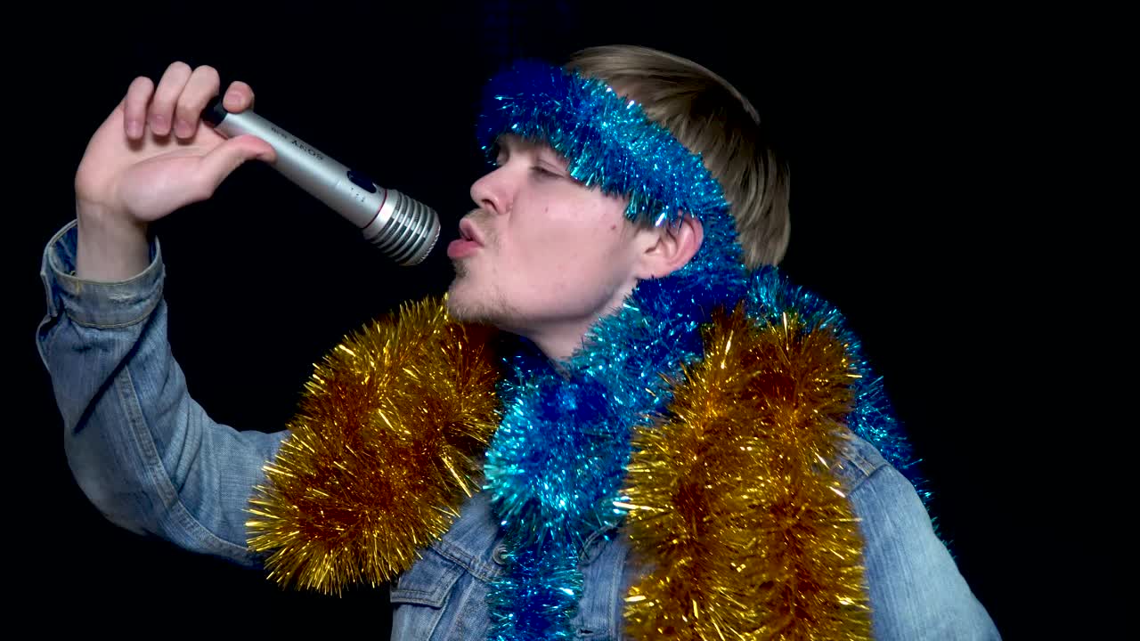 마이크 를 들고 축하 하는 틴셀 과 젠임 재 을 입은 남자