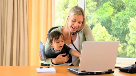 baby helping mother with office work