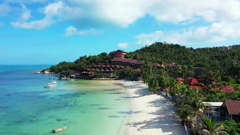Paradise-vacations-destination-with-luxurious-waterfront-resort-near-exotic-beach-with-white-sand-washed-by-calm-turquoise-lagoon-in-Thailand