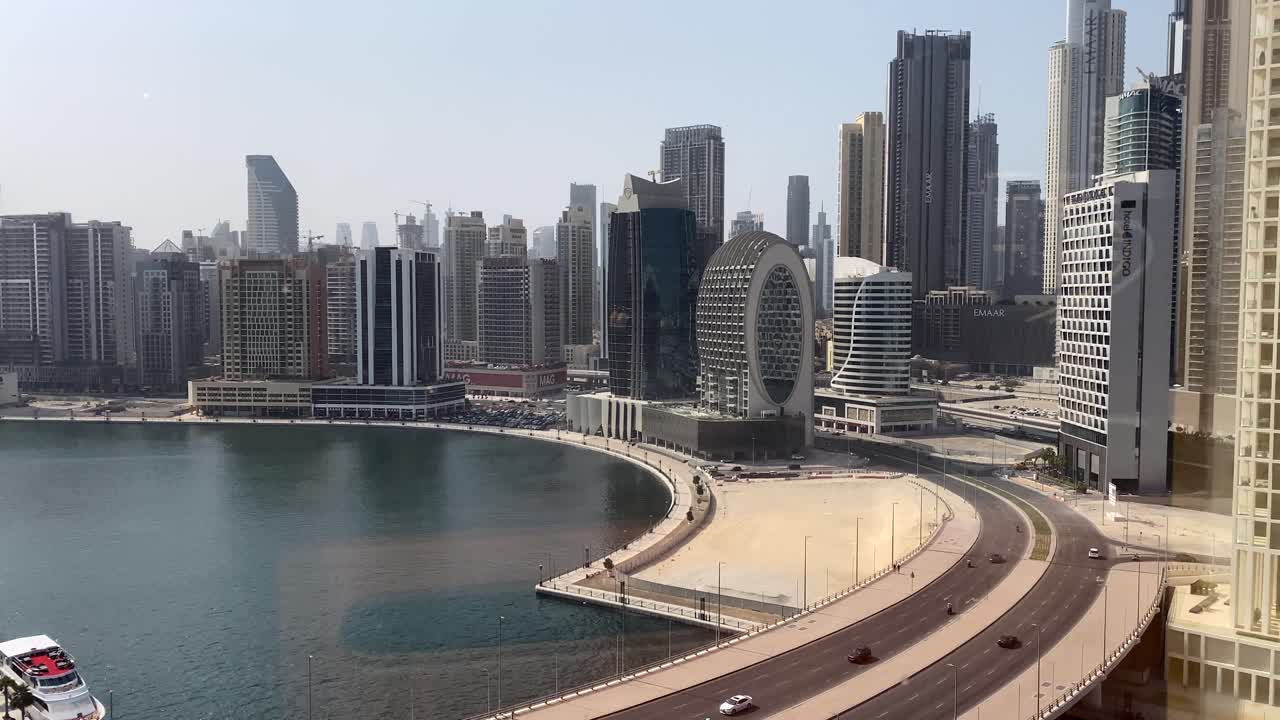 Timelapse over Business Bay in Dubai with view of the Burj Khalifa and canal with traffic over the bridge November