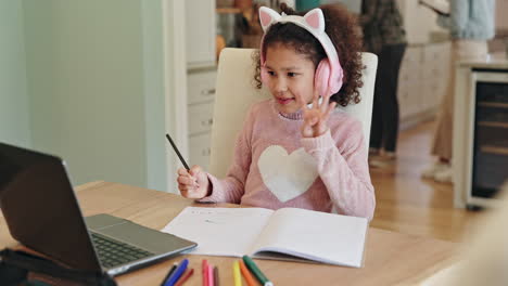 child doing homework with laptop and headphones