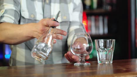Bartender prepares Sambuca at the bar. Concept of services and beverages.