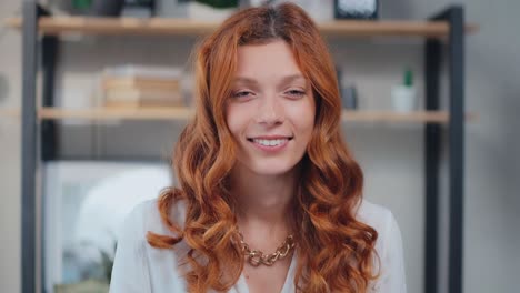 young caucasian woman looking at camera cutely blinking and smiling
