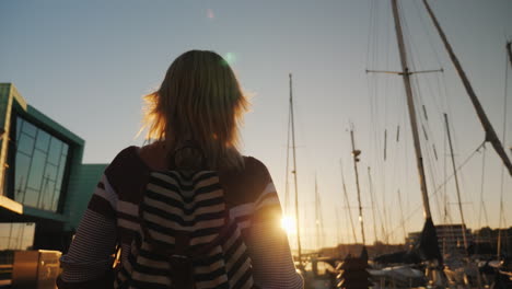 a young woman strolls along the prestigious district of bergen near the pier with yachts the setting