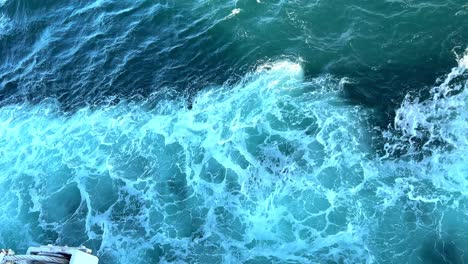 cargo ship in the english channel. blue water giving rise to a white waves