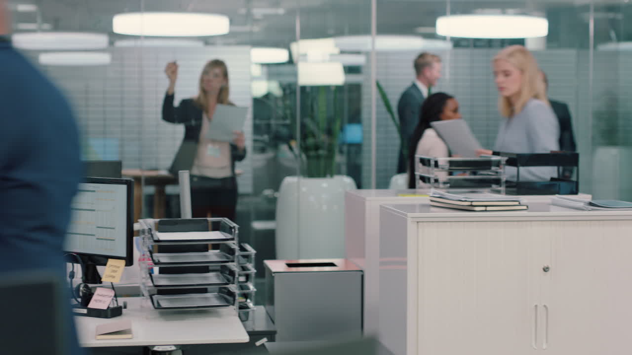 전화 를 사용 하고 전화 통화 를 하고 고객 과 채팅 하는 자신감 있는 판매원 보험 중개인 의 책상 에 앉아 바쁜 사무실 에서 판매 를 논의 하고 있다