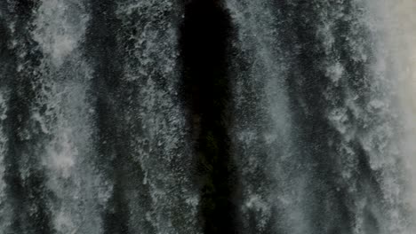 waterfall cascading down rocks, iguazu falls on the border of brazil and argentina - tilt down shot