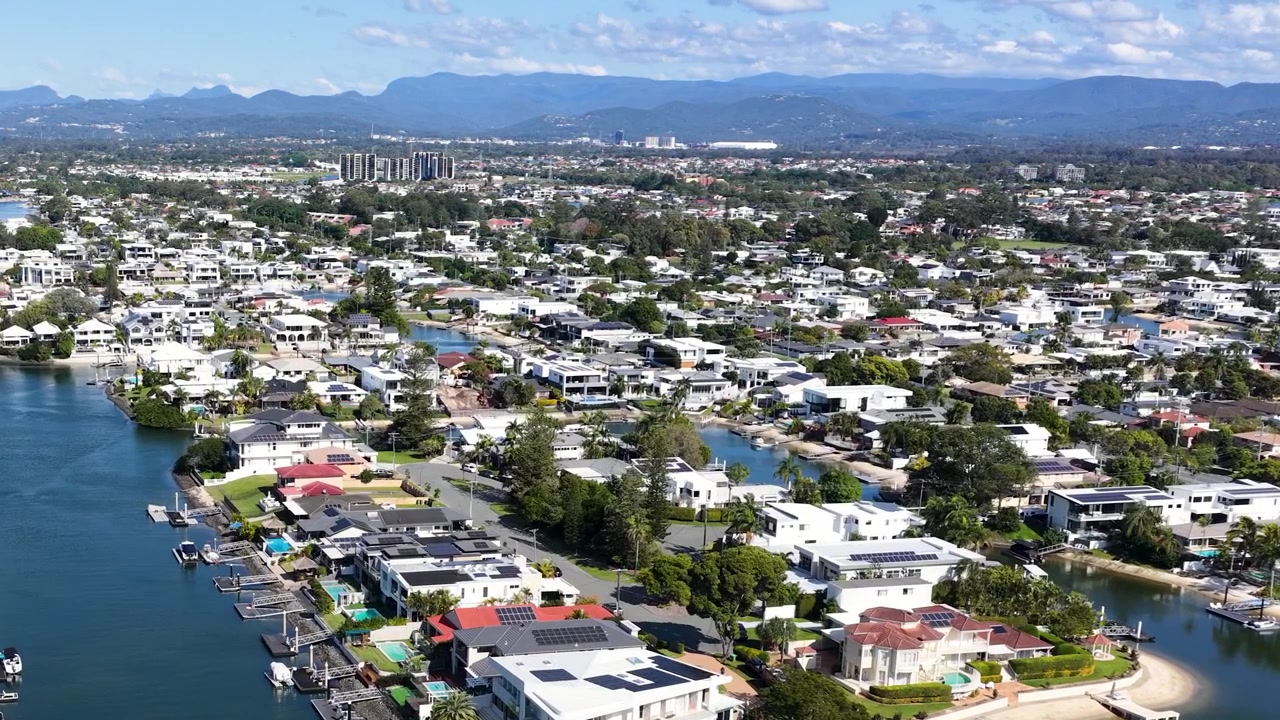 Toma aérea con dron captura casas suburbanas de lujo a lo largo de canales serpenteantes bajo la luz del día
