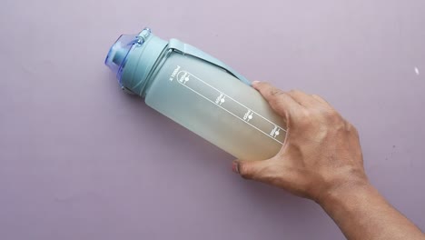 person holding a gray plastic water bottle