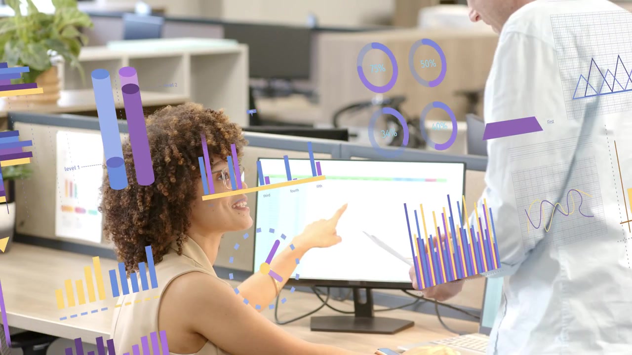 Woman typing at monitor coworker walking in with papers, floating charts showing business metrics