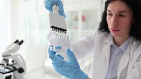 scientist performing laboratory experiment with multi-channel pipette and petri dish