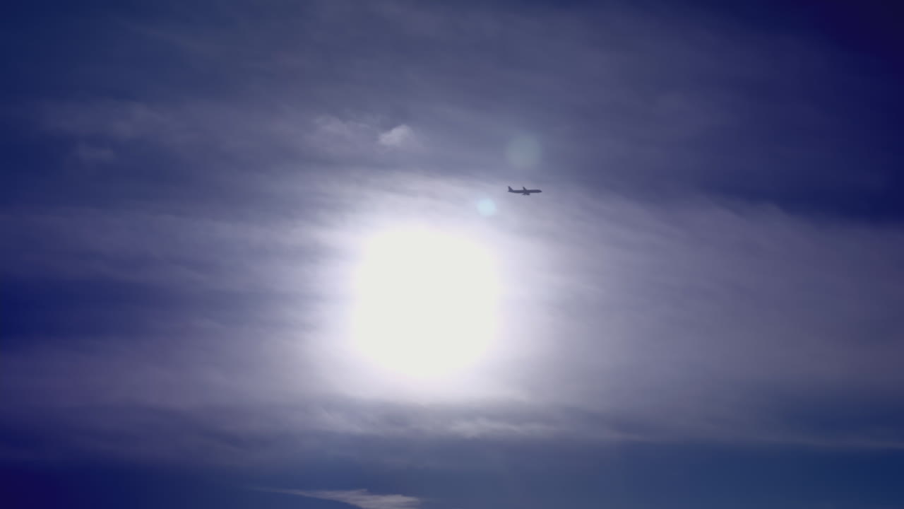 самолет в облачном небе с солнцем